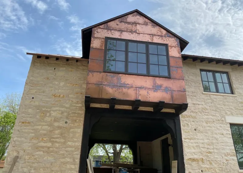 Copper metal panel facade on a stone building for Skylight Installation in Bruce