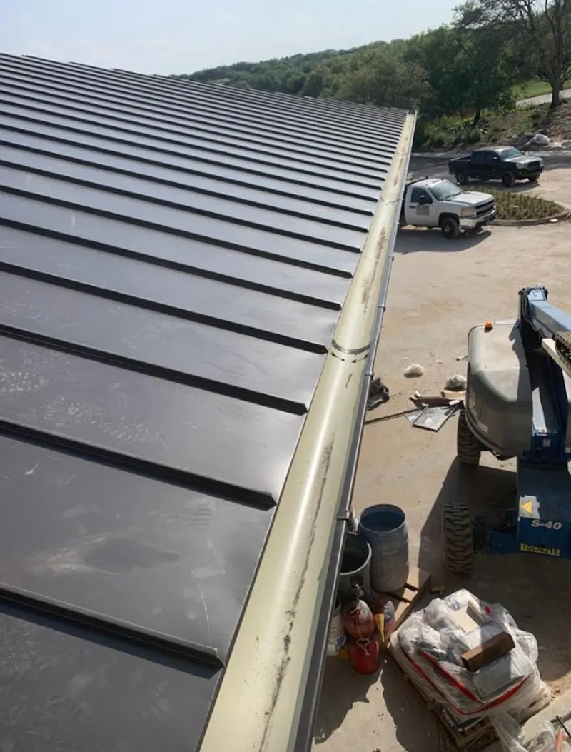 Standing seam panel and gutter detail on a metal roofing jobsite in Bruce